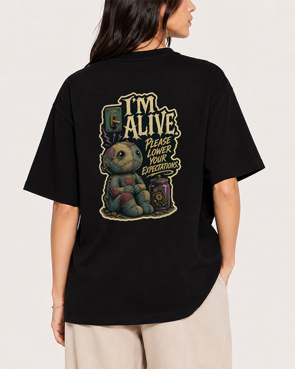Alive, Please Lower Your Expectations Funny Graphic T-Shirt in Black, back model view 1