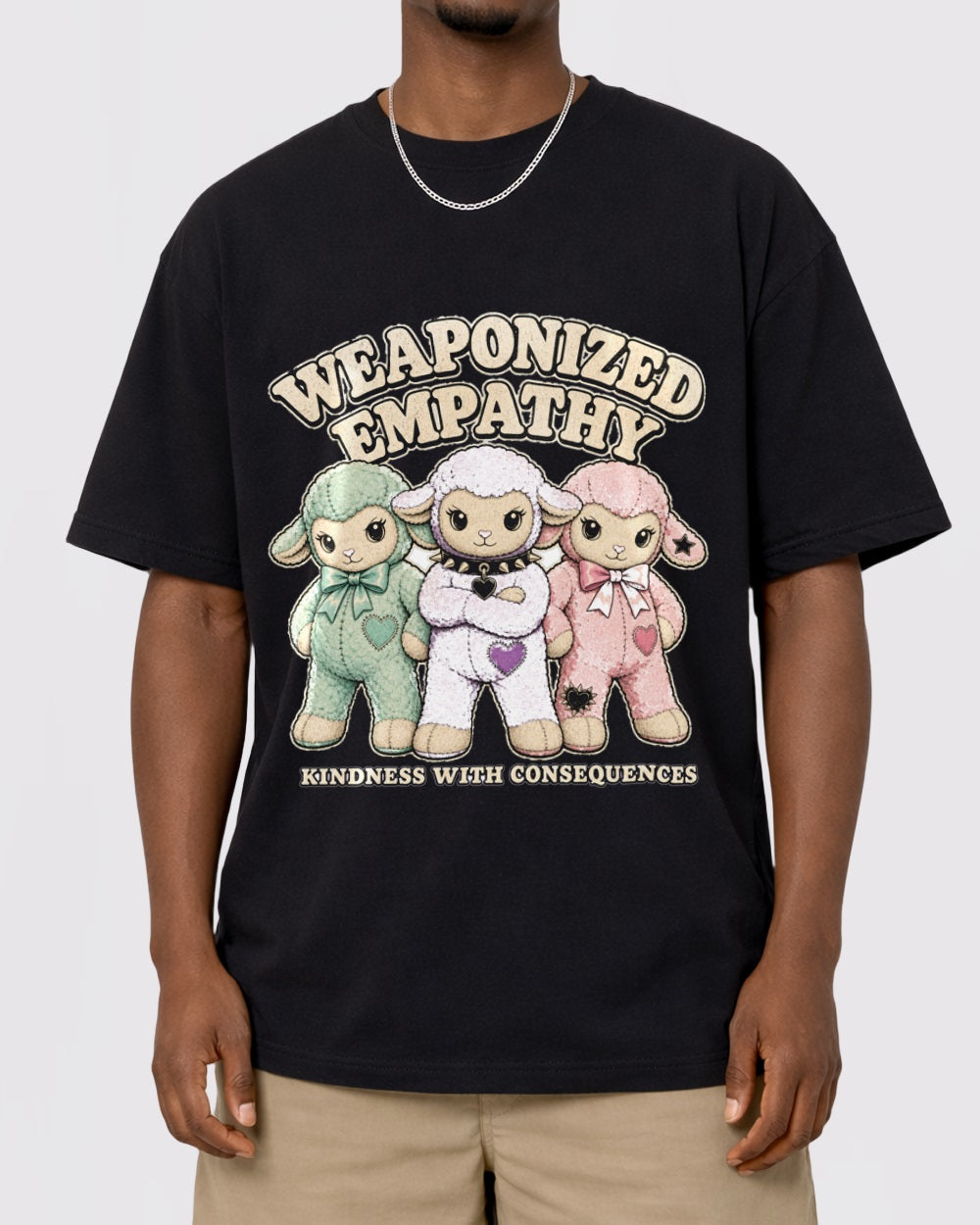 Black T-shirt front view with three pastel sheep and Weaponized Empathy graphic